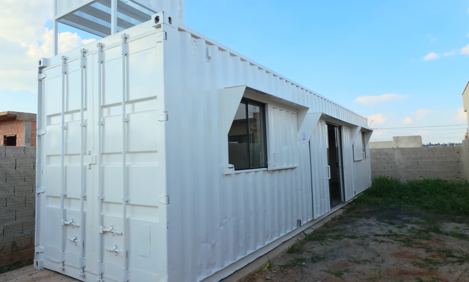 Fachada frontal branca do container 30 m² com portas e janelas